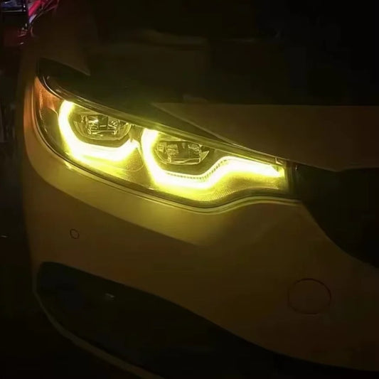 CSL-style yellow DRL lit on an F8X headlight at night